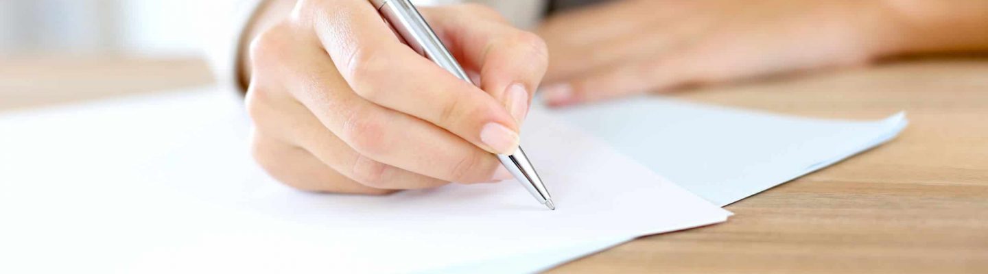 Employment Law image of person writing on a contract