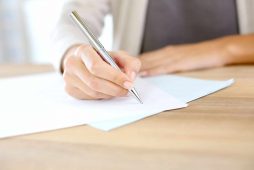 Employment Law image of person writing on a contract
