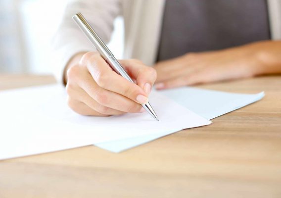 Employment Law image of person writing on a contract