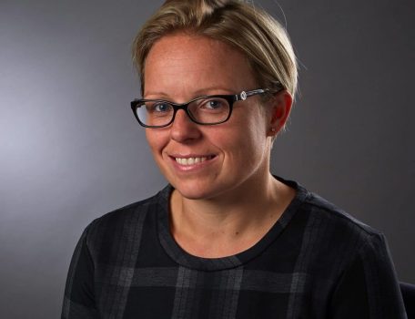 new partner Tara Crisp headshot of woman with short hair and glasses