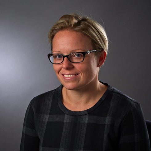 new partner Tara Crisp headshot of woman with short hair and glasses