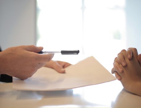 Image for white men sitting at table with paper and pen for the trust registration blog