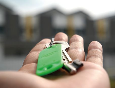 Picture of hand with house keys on green keyring for Conveyancing process blog