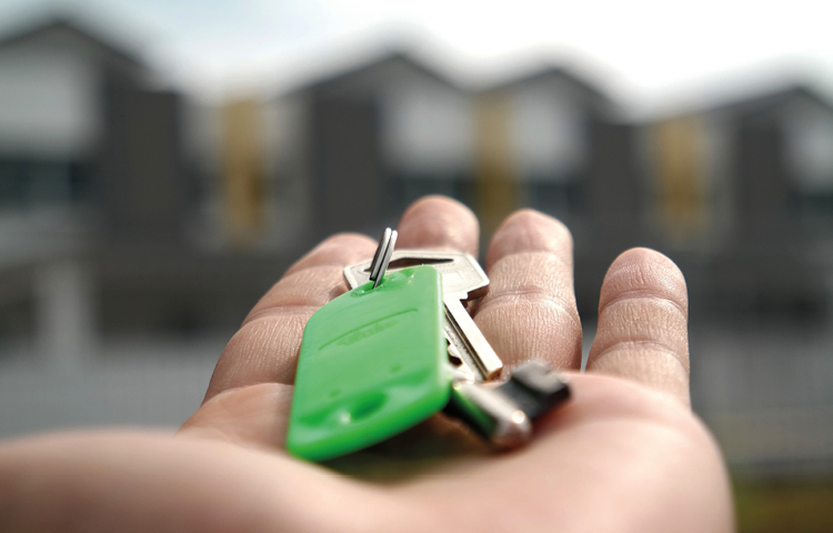 Picture of hand with house keys on green keyring for Conveyancing process blog