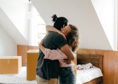 Cohabitation Law Image of couple hugging surrounded by packing boxes in new home