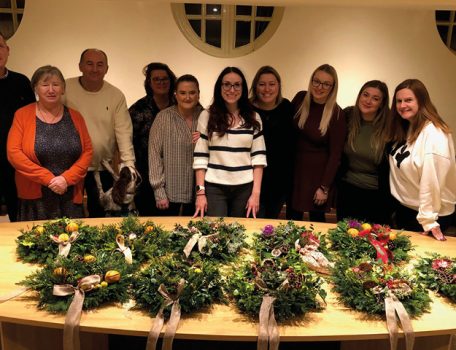 Community Round up 2022 picture of some of the Hibberts Team with Christmas wreaths