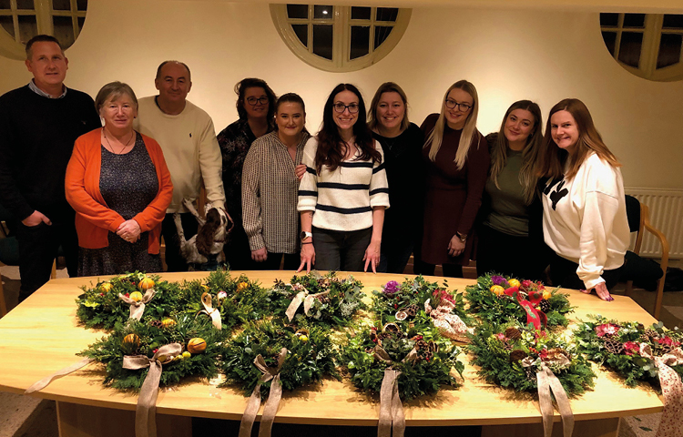 Community Round up 2022 picture of some of the Hibberts Team with Christmas wreaths