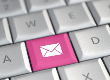 Image of computer keyboard with one key replaced in pink by an envelope icon representing an email signature