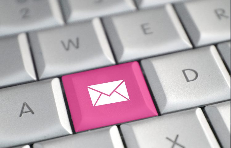 Image of computer keyboard with one key replaced in pink by an envelope icon representing an email signature