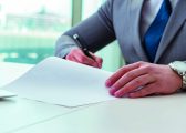 Man sitting at desk writing on paper to represent Labour's new Make Work Pay employment plan