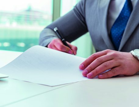 Man sitting at desk writing on paper to represent Labour's new Make Work Pay employment plan