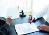 law, libra scale and hammer on the table, 2 men are dealing and signing commercial contract, law matters determination