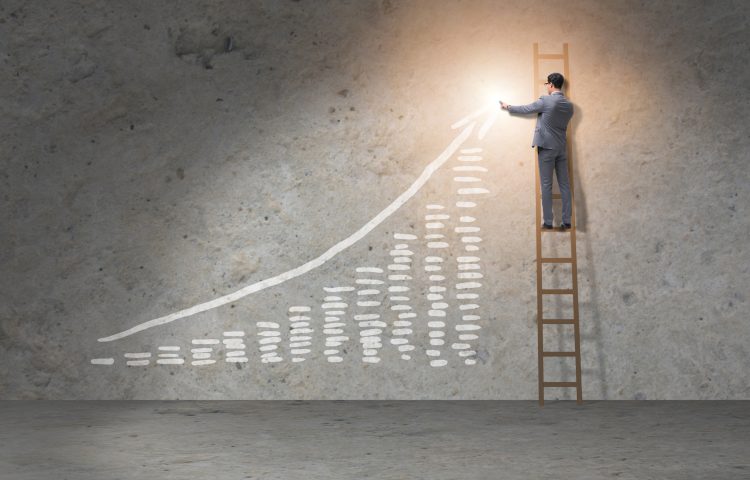Image of graph showing an increase from left to right with a man in a suit on a ladder pointing to the top right side of the graph to represent The Economic Crime and Corporate Transparency Act 2023