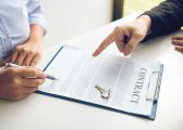 image of two peoples hands, one pointing at a contract on a clipboard and the other poised to sign it for the Hibberts Blog The Landlord and Tenant Act 1954 - Review and Consultation