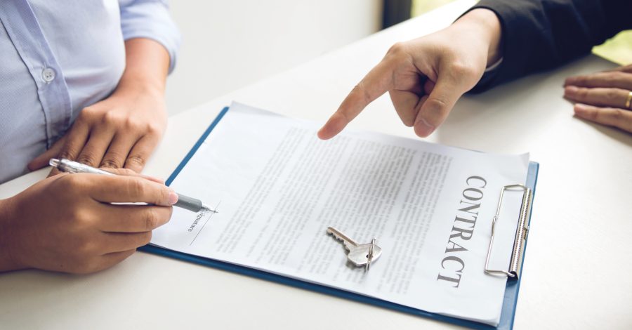 image of two peoples hands, one pointing at a contract on a clipboard and the other poised to sign it for the Hibberts Blog The Landlord and Tenant Act 1954 - Review and Consultation
