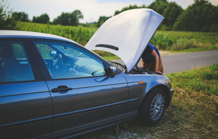 Image of a broken down car at the side of the road with the bonnet up and the driver looking under the bonnet for the Faulty Car After Purchase? Know Your Consumer Rights UK blog