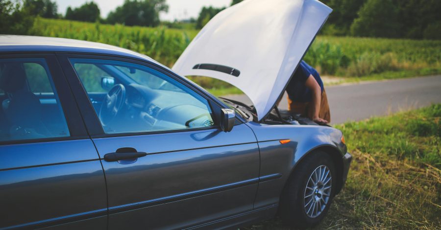 Image of a broken down car at the side of the road with the bonnet up and the driver looking under the bonnet for the Faulty Car After Purchase? Know Your Consumer Rights UK blog