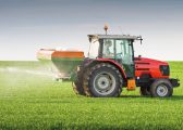 Image of a red tractor on a spraying a green field for the Inheritance Tax Blog